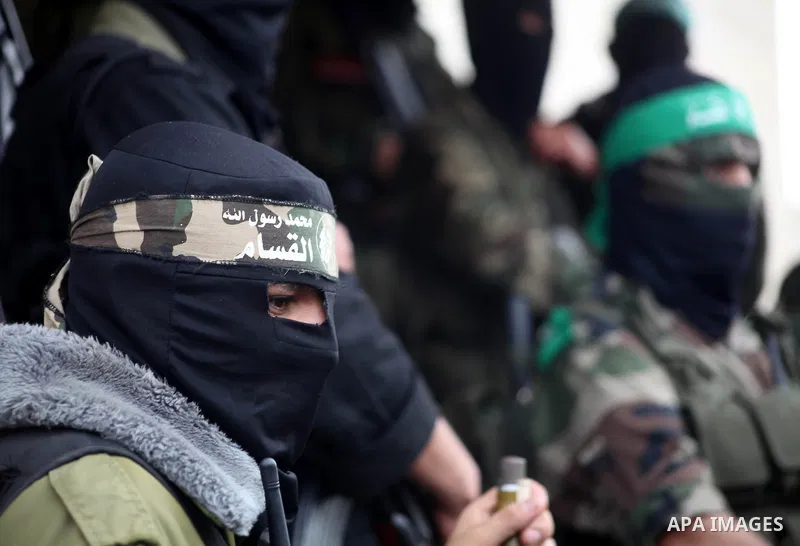 Members of the Ezzedine al-Qassam brigades, the armed wing of Hamas, carry their weapons as they celebrate after the truce between Gaza and Israel came into effect, in the Nusseirat refugee camp in the central Gaza Strip...
