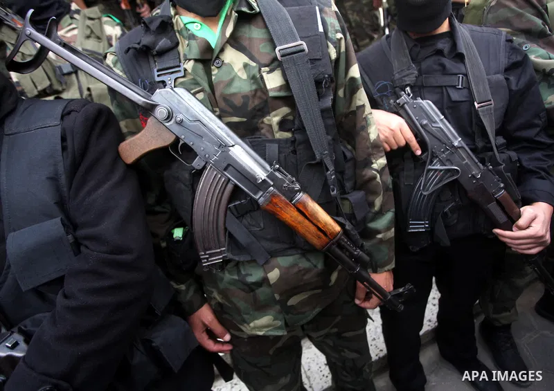 Members of the Ezzedine al-Qassam brigades, the armed wing of Hamas, carry their weapons as they celebrate after the truce between Gaza and Israel came into effect, in the Nusseirat refugee camp in the central Gaza Strip...