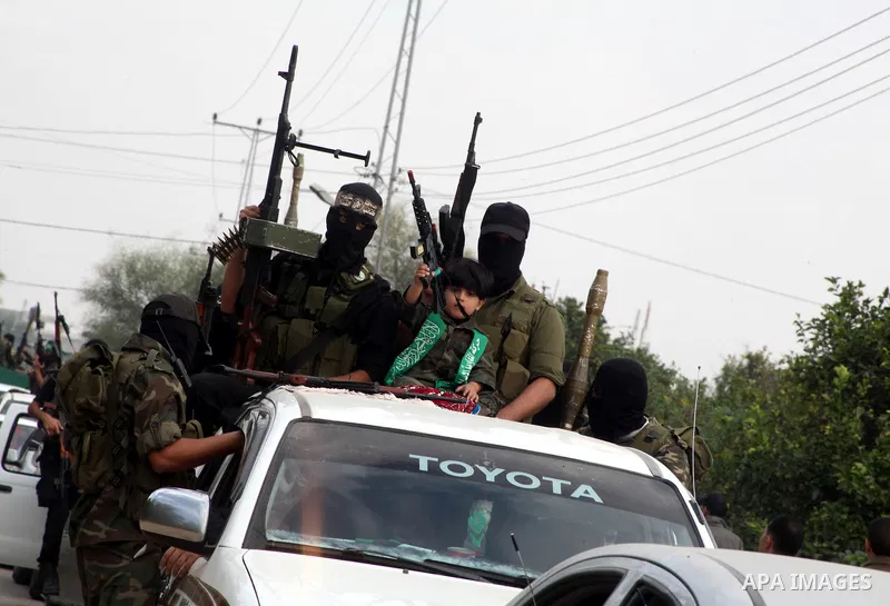 Hamas militants ride in a pick-up truck as they take part in the funeral of their comrades, whom medics said were killed in Israeli air strikes on Wednesday, in the central Gaza Strip November 22, 2012. A ceasefire betwe...