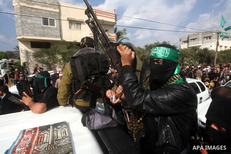 Hamas militants ride in a pick-up truck as they take part in the funeral of their comrades, whom medics said were killed in Israeli air strikes on Wednesday, in the central Gaza Strip November 22, 2012. A ceasefire betwe...