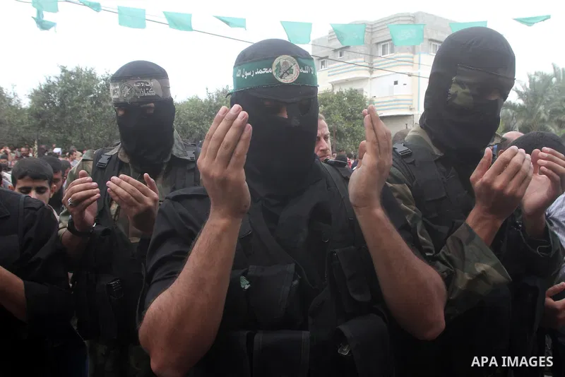Members of the Ezzedine al-Qassam brigades, the armed wing of Hamas, carry their weapons as they celebrate after the truce between Gaza and Israel came into effect, in the Nusseirat refugee camp in the central Gaza Strip...