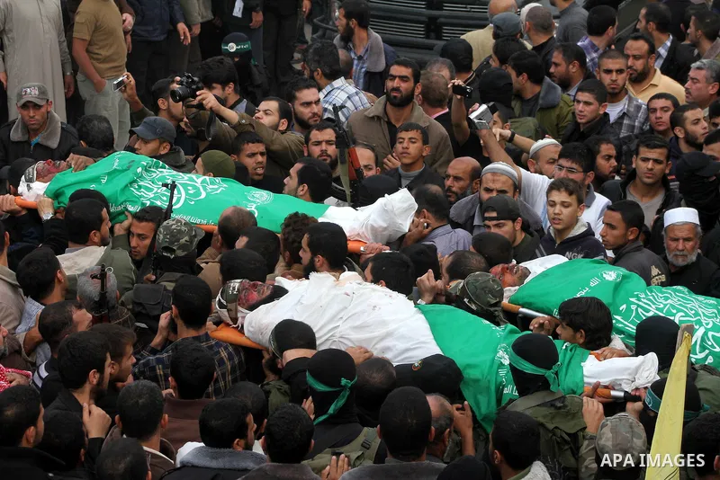 Mourners carry the bodies of Hamas militants in Al Moghraqa in the central Gaza Strip, 22 November 2012. Five Hamas militants were reportedly killed 21 November 2012 after an Israeli air strike on the house of the Abu Km...
