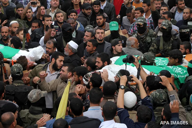 Mourners carry the bodies of Hamas militants in Al Moghraqa in the central Gaza Strip, 22 November 2012. Five Hamas militants were reportedly killed 21 November 2012 after an Israeli air strike on the house of the Abu Km...