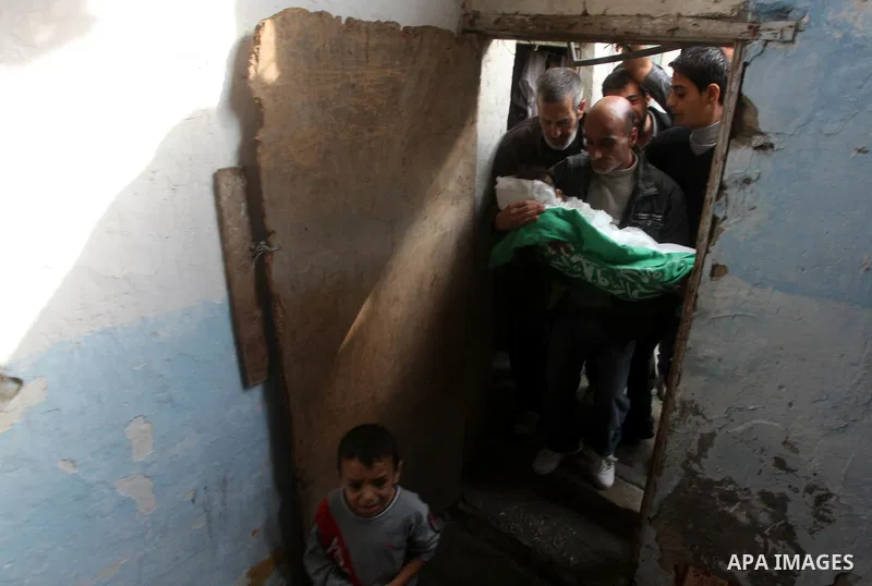 A man holds the body of his daughter, three-year-old Reham Al Nabaheen, during her funeral at Al Nusairat refugee camp in central Gaza Strip, 22 November 2012. Reham Al Nabaheen was reportedly killed after an Israeli air...