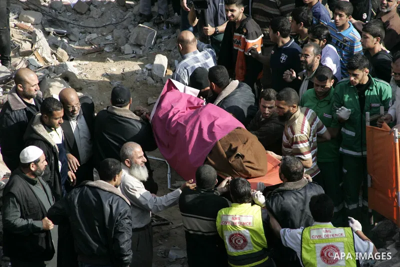 Palestinians carry the dead body of a man from the al-Dallu family out from the rubble after A ceasefire between Israel and Gaza's Hamas Who was killed an Israeli airstrike in Gaza City, on November 18, 2012. Ten Palesti...