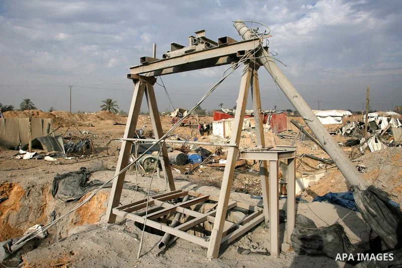 Palestinians walk past a crater near bombed smuggling tunnels between the southern Gaza Strip and Egypt in the border town of Rafah on November 22, 2012. A ceasefire took hold in and around Gaza after a week of cross-bor...