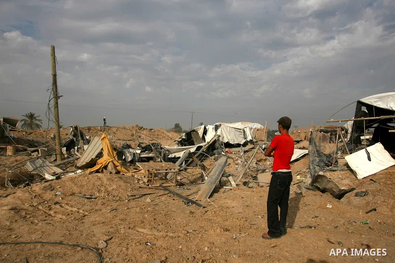 Palestinians walk past a crater near bombed smuggling tunnels between the southern Gaza Strip and Egypt in the border town of Rafah on November 22, 2012. A ceasefire took hold in and around Gaza after a week of cross-bor...