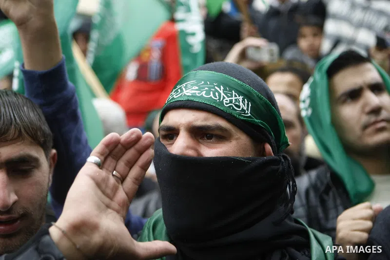 Palestinian supporters of the Islamist movement Hamas gesture and wave the movement's flag during a demonstration in the West Bank city of Hebron on November 23, 2012. Photo by Mamoun Wazwaz
