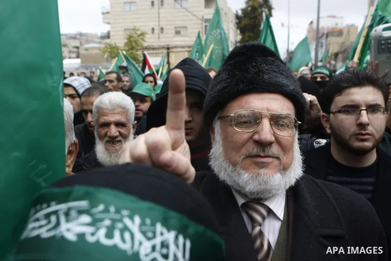 Palestinian supporters of the Islamist movement Hamas gesture and wave the movement's flag during a demonstration in the West Bank city of Hebron on November 23, 2012. Photo by Mamoun Wazwaz