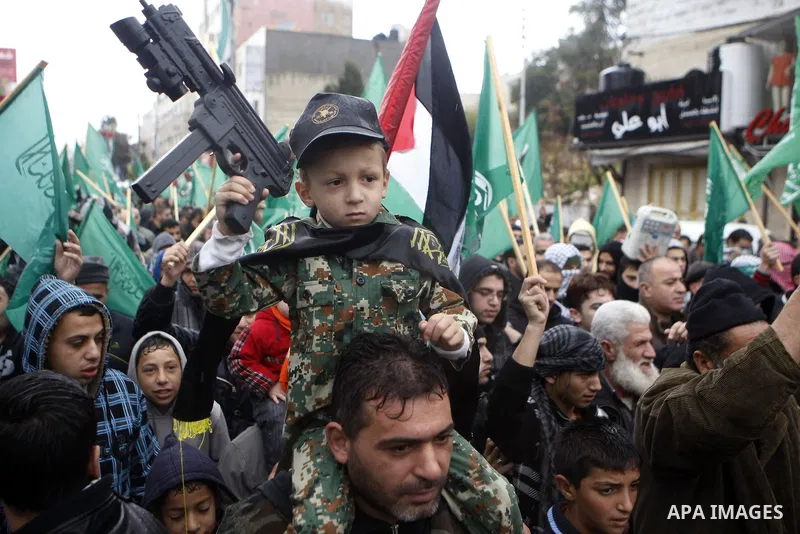Palestinian supporters of the Islamist movement Hamas gesture and wave the movement's flag during a demonstration in the West Bank city of Hebron on November 23, 2012. Photo by Mamoun Wazwaz