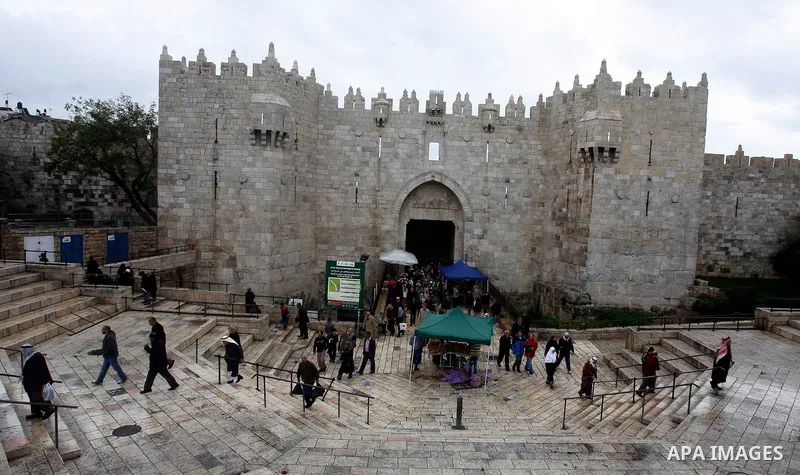 Palestinians walk past Israeli security forces at the entrance of Jerusalem's Old City next to the Damascus Gate on November 23, 2012. The Israeli army said it had arrested 55 Palestinian "terror operatives" across the W...