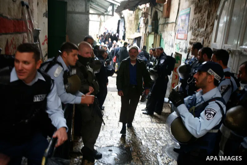 Palestinians walk past Israeli security forces at the entrance of Jerusalem's Old City next to the Damascus Gate on November 23, 2012. The Israeli army said it had arrested 55 Palestinian "terror operatives" across the W...
