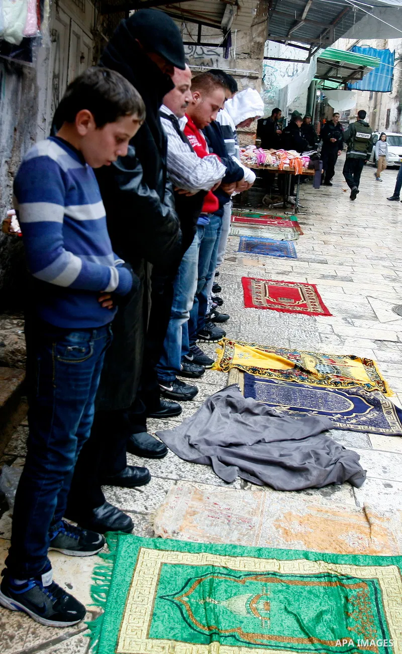 Palestinians walk past Israeli security forces at the entrance of Jerusalem's Old City next to the Damascus Gate on November 23, 2012. The Israeli army said it had arrested 55 Palestinian "terror operatives" across the W...