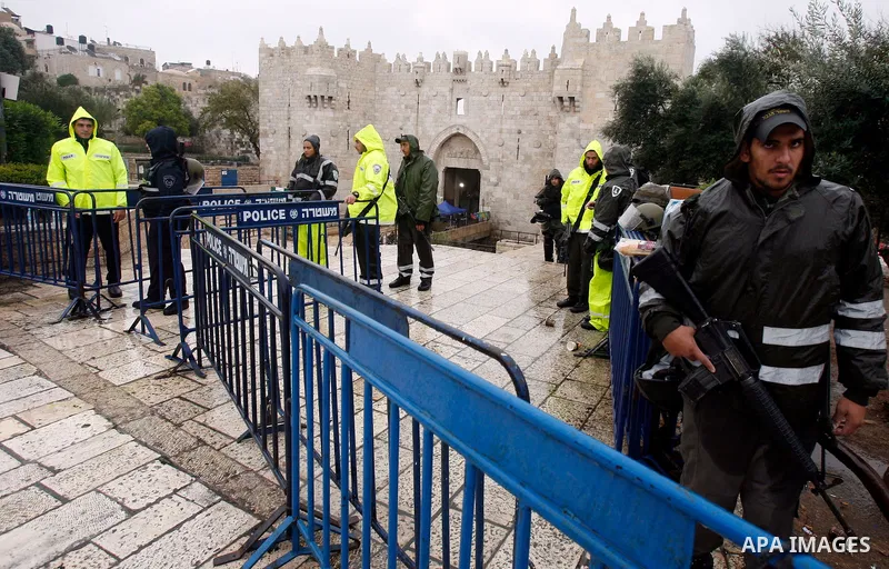 Palestinians walk past Israeli security forces at the entrance of Jerusalem's Old City next to the Damascus Gate on November 23, 2012. The Israeli army said it had arrested 55 Palestinian "terror operatives" across the W...
