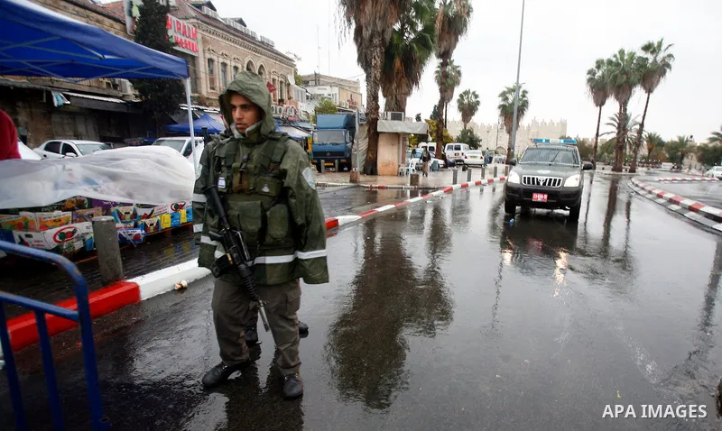 Palestinians walk past Israeli security forces at the entrance of Jerusalem's Old City next to the Damascus Gate on November 23, 2012. The Israeli army said it had arrested 55 Palestinian "terror operatives" across the W...
