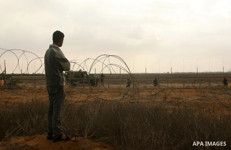 A Palestinian man stands on the border between Gaza strip and Israel in the east of Khan Younis southern Gaza strip November 23, 2012. Israeli troops at the Gaza border shot dead a Palestinian man and wounded 15 more on...