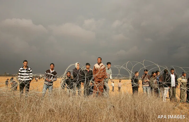 Palestinians stand on the border between Gaza strip and Israel in the east of Khan Younis southern Gaza strip November 23, 2012. Israeli troops at the Gaza border shot dead a Palestinian man and wounded 15 more on Friday...