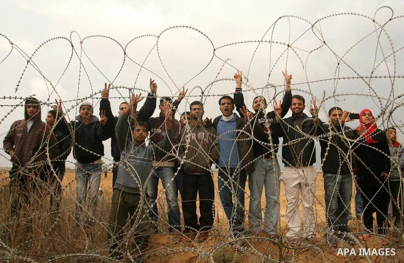 Palestinians stand on the border between Gaza strip and Israel in the east of Khan Younis southern Gaza strip November 23, 2012. Israeli troops at the Gaza border shot dead a Palestinian man and wounded 15 more on Friday...