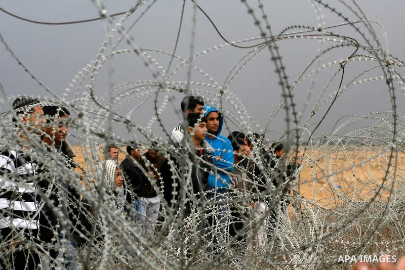 Palestinians stand on the border between Gaza strip and Israel in the east of Khan Younis southern Gaza strip November 23, 2012. Israeli troops at the Gaza border shot dead a Palestinian man and wounded 15 more on Friday...