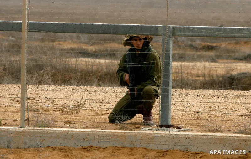 An Israeli soldier stands ready on the border between Gaza strip and Israel in the east of Khan Younis southern Gaza strip November 23, 2012. Israeli troops at the Gaza border shot dead a Palestinian man and wounded 15 m...