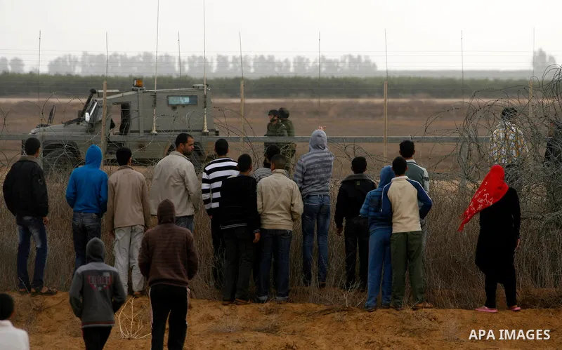 Palestinians stand on the border between Gaza strip and Israel in the east of Khan Younis southern Gaza strip November 23, 2012. Israeli troops at the Gaza border shot dead a Palestinian man and wounded 15 more on Friday...