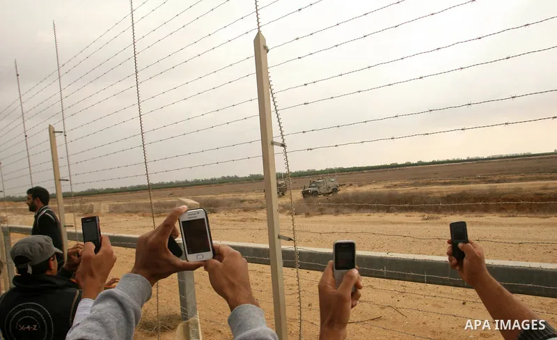 Palestinians stand on the border between Gaza strip and Israel in the east of Khan Younis southern Gaza strip November 23, 2012. Israeli troops at the Gaza border shot dead a Palestinian man and wounded 15 more on Friday...