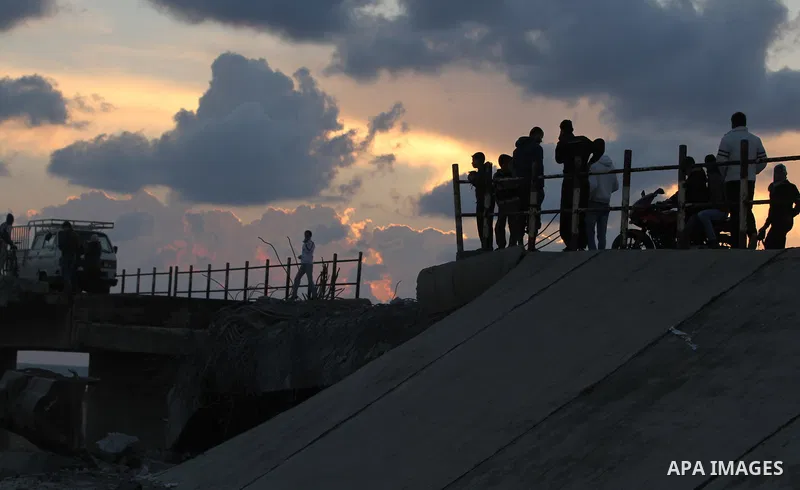 Palestinians look at Wadi Gaza bridge, a strategic link between the northern and southern areas of the Gaza Strip, following an Israeli air strike, November 23, 2012. Palestinians and Israelis on both sides of the Gaza b...