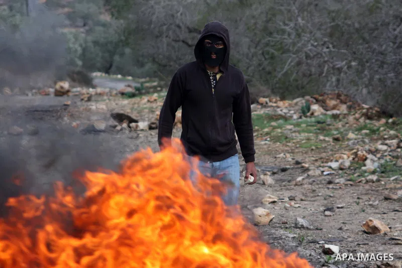 Palestinian protesters make their road blocks during the weekly protest against the Jewish settlement of Qadomem, near Nablus, West Bank, 23 November 2012. Photo by Nedal Eshtayah