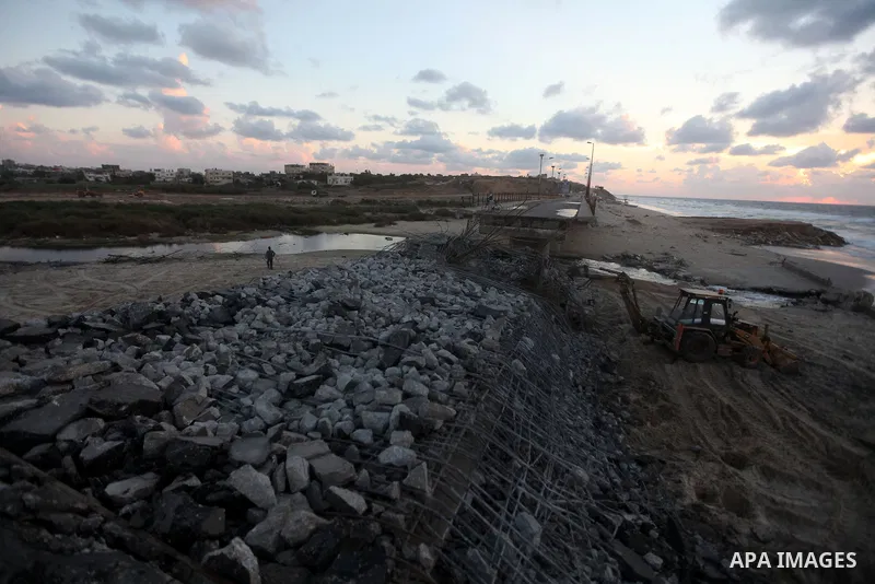 Palestinians look at Wadi Gaza bridge, a strategic link between the northern and southern areas of the Gaza Strip, following an Israeli air strike, November 23, 2012. Palestinians and Israelis on both sides of the Gaza b...