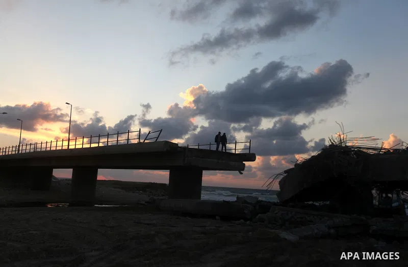 Palestinians look at Wadi Gaza bridge, a strategic link between the northern and southern areas of the Gaza Strip, following an Israeli air strike, November 23, 2012. Palestinians and Israelis on both sides of the Gaza b...