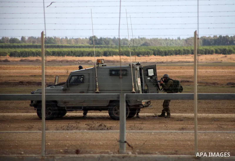 Israeli troops stand guard near the Israeli Gaza border fence in east of Khan Younis, southern Gaza Strip, Friday, Nov. 23, 2012. Hundreds of Gaza crowds surged toward Israel's border fence with the Hamas-ruled territory...