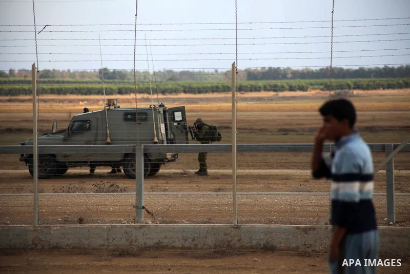 Israeli troops stand guard near the Israeli Gaza border fence in east of Khan Younis, southern Gaza Strip, Friday, Nov. 23, 2012. Hundreds of Gaza crowds surged toward Israel's border fence with the Hamas-ruled territory...
