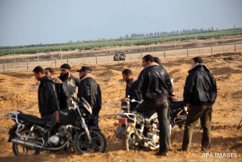 Palestinians ride there motorcycles near the Israeli Gaza border fence in east of Khan Younis, southern Gaza Strip, Friday, Nov. 23, 2012. Hundreds of Gaza crowds surged toward Israel's border fence with the Hamas-ruled...