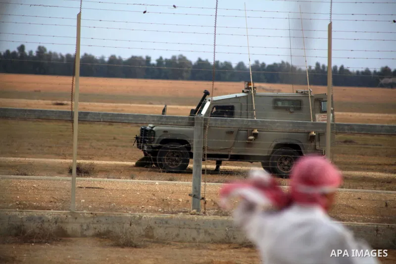 Palestinians stand near the Israeli Gaza border fence in east of Khan Younis, southern Gaza Strip, Friday, Nov. 23, 2012. Hundreds of Gaza crowds surged toward Israel's border fence with the Hamas-ruled territory, in a n...