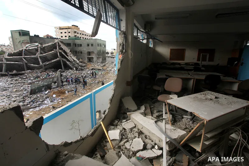 Palestinians school girls walk on the rubble of a building destroyed during earlier Israeli bombardment, as they make their way to their nearby school in Gaza City, on November 24, 2012, three days after a truce was decl...