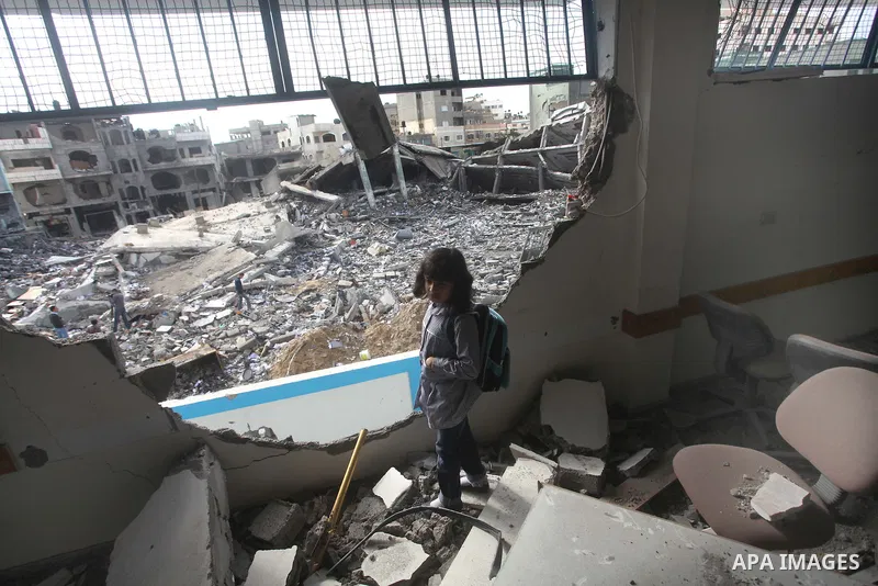 Palestinians school girls walk on the rubble of a building destroyed during earlier Israeli bombardment, as they make their way to their nearby school in Gaza City, on November 24, 2012, three days after a truce was decl...