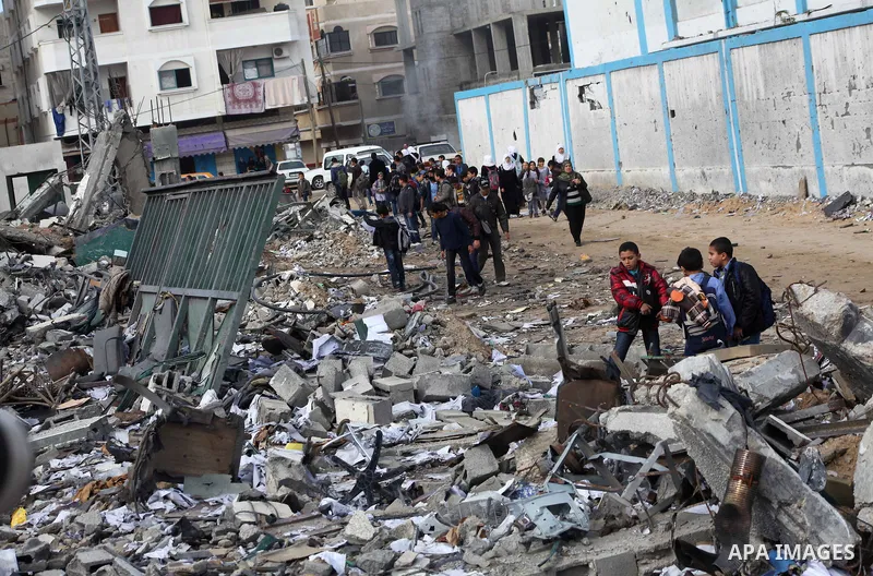Palestinians school buys walk on the rubble of a building destroyed during earlier Israeli bombardment, as they make their way to their nearby school in Gaza City, on November 24, 2012, three days after a truce was decla...