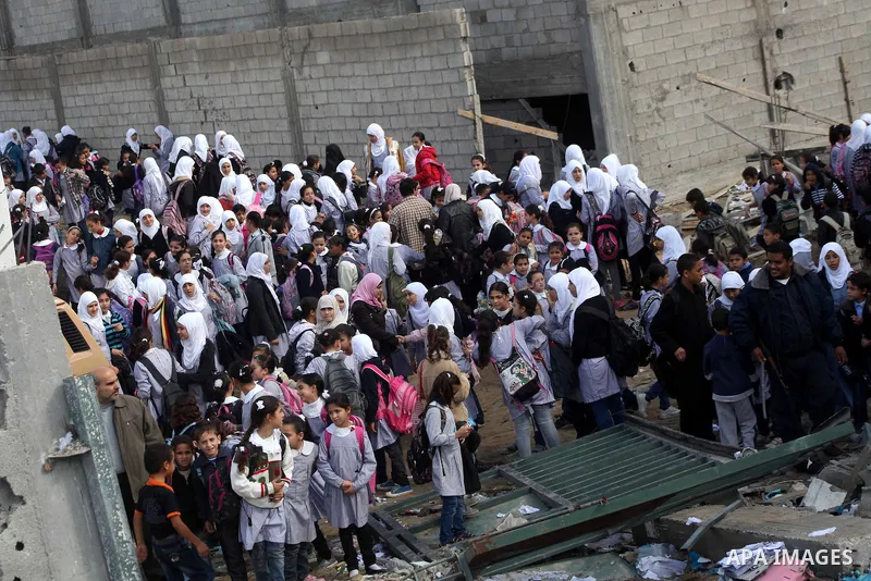 Palestinians school girls walk on the rubble of a building destroyed during earlier Israeli bombardment, as they make their way to their nearby school in Gaza City, on November 24, 2012, three days after a truce was decl...