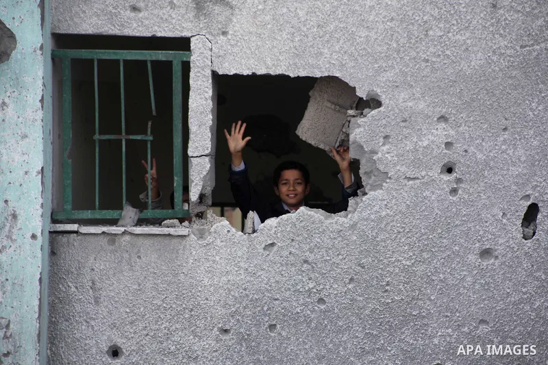 A Palestinian school boy looks through a hole at their damaged United Nations run school in Gaza City, on November 24, 2012, three days after a truce was declared between Israel and Hamas. Gaza's children, virtually abse...