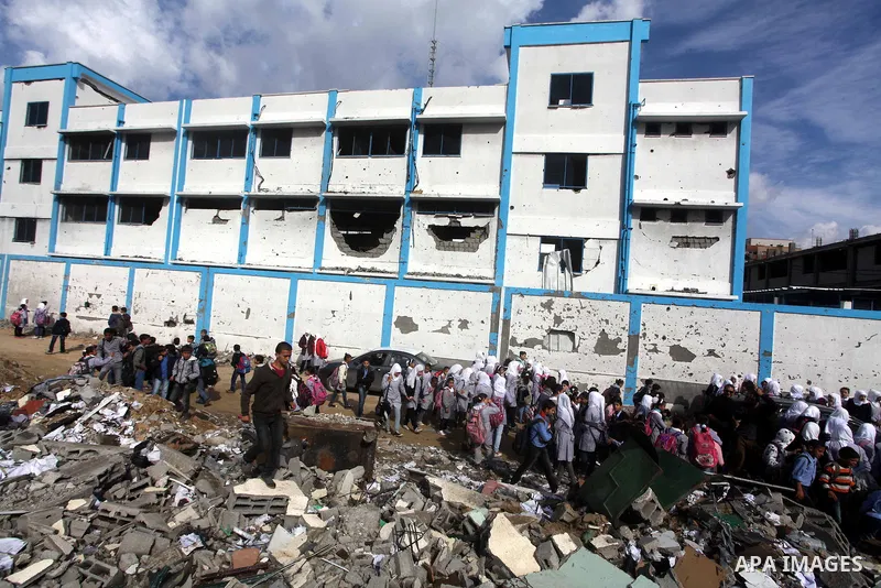 Palestinians school girls walk on the rubble of a building destroyed during earlier Israeli bombardment, as they make their way to their nearby school in Gaza City, on November 24, 2012, three days after a truce was decl...