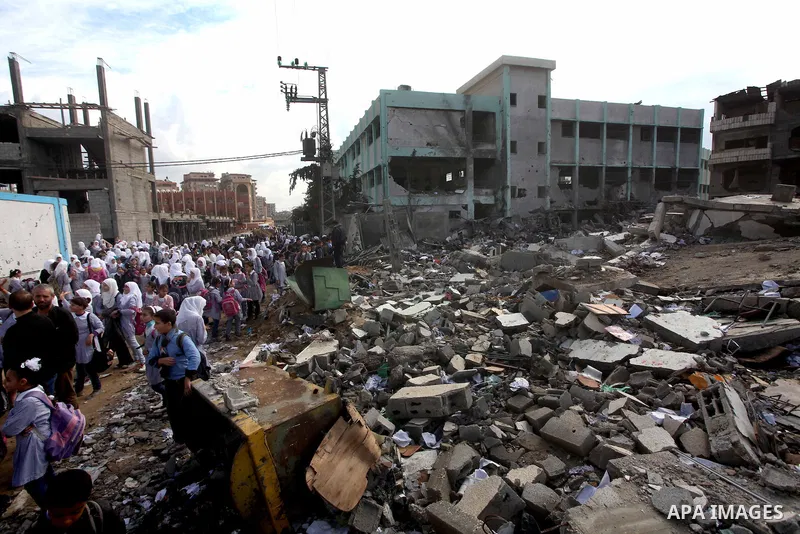Palestinians school girls walk on the rubble of a building destroyed during earlier Israeli bombardment, as they make their way to their nearby school in Gaza City, on November 24, 2012, three days after a truce was decl...