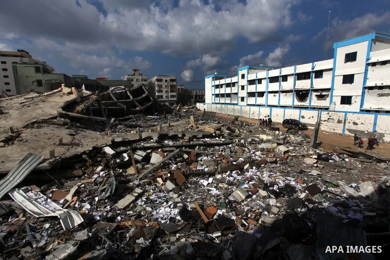 Palestinians school girls walk on the rubble of a building destroyed during earlier Israeli bombardment, as they make their way to their nearby school in Gaza City, on November 24, 2012, three days after a truce was decl...