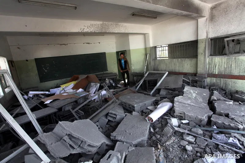 Palestinians school girls walk on the rubble of a building destroyed during earlier Israeli bombardment, as they make their way to their nearby school in Gaza City, on November 24, 2012, three days after a truce was decl...