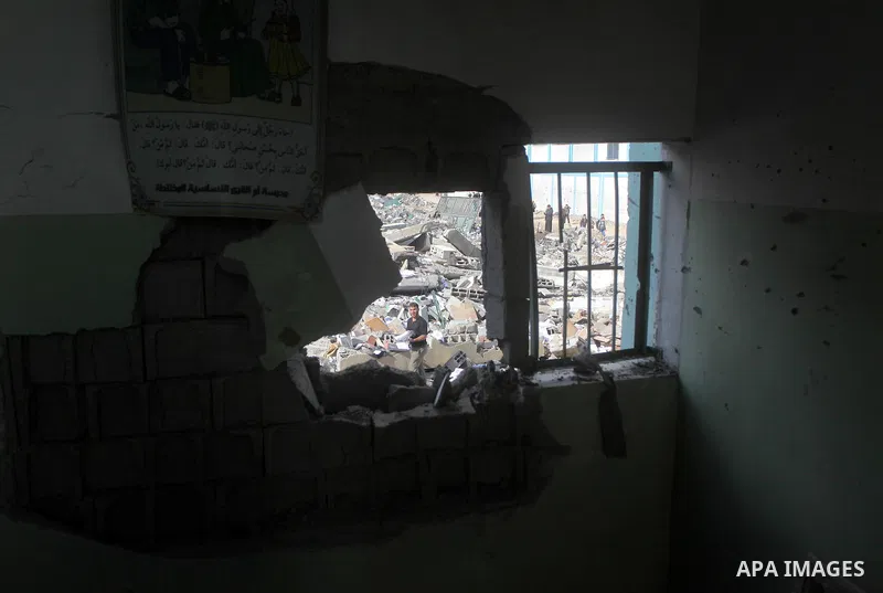A Palestinian school boy looks through a hole at their damaged United Nations run school in Gaza City, on November 24, 2012, three days after a truce was declared between Israel and Hamas. Gaza's children, virtually abse...