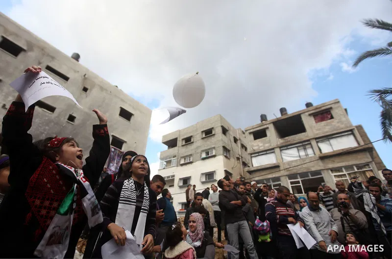 Palestinians release balloons at the site of the destroyed house of the Dalou family in Gaza City November 24, 2012. Eleven members of the Dalou family were killed after an Israeli air strike on their house during the ei...