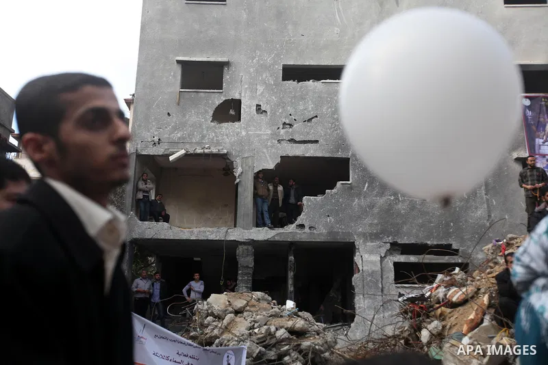 Palestinians release balloons at the site of the destroyed house of the Dalou family in Gaza City November 24, 2012. Eleven members of the Dalou family were killed after an Israeli air strike on their house during the ei...