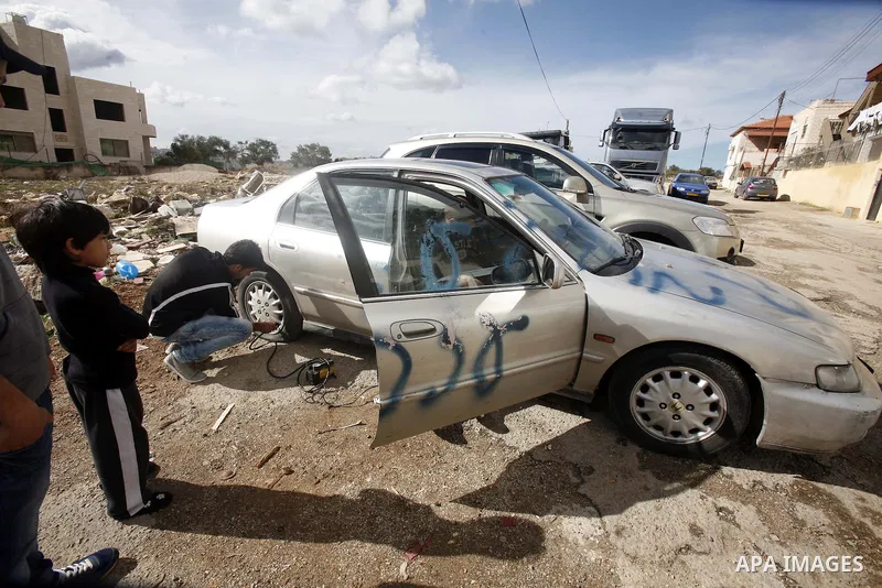 A Palestinian man inspects a car with a graffiti reading in Hebrew "Gaza: the price to pay" in the Palestinian neighborhood of Shuafat in Israeli annexed East Jerusalem, , on November 25, 2012. Unknown assailants vandali...