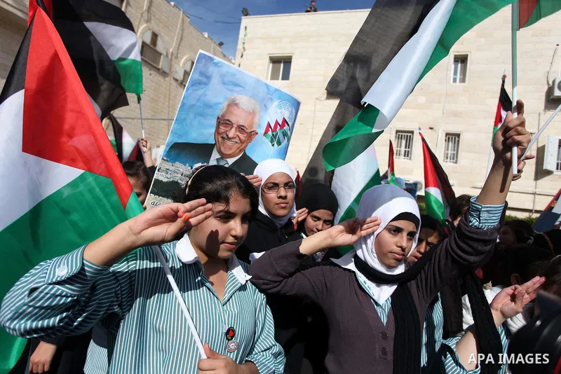 Palestinians hold posters of Palestinian President Mahmoud Abbas during a rally supporting the Palestinian UN bid for observer state status, in the West Bank city of Ramallah, Sunday, Nov. 25, 2012. The Palestinians will...