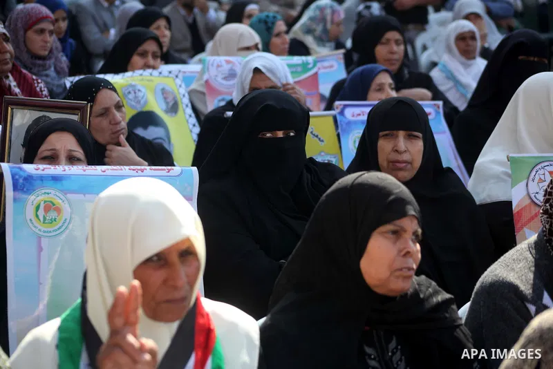 Palestinian women hold a poster of Palestinian prisoners during a protest calling for the release them from Israeli jails and in support of prisoners on hunger strike in front of Red Cross, in Gaza city on 26 November 20...