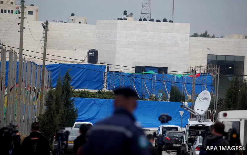 workers and an unidentified man wearing a forensic protective suit stand in front the mausoleum of the later Palestinian leader Yasser Arafat, on November 27, 2012, at the Muqataa in the West Bank city of Ramallah. The r...